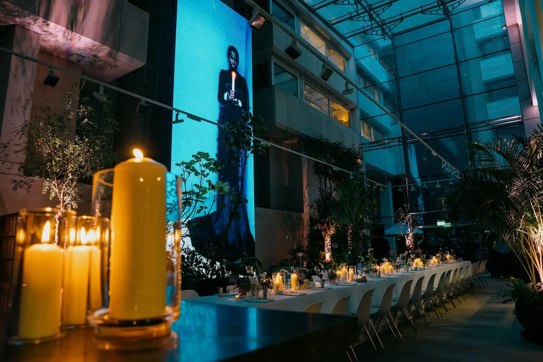 A candlelit event dinner in a glass-roofed atrium
