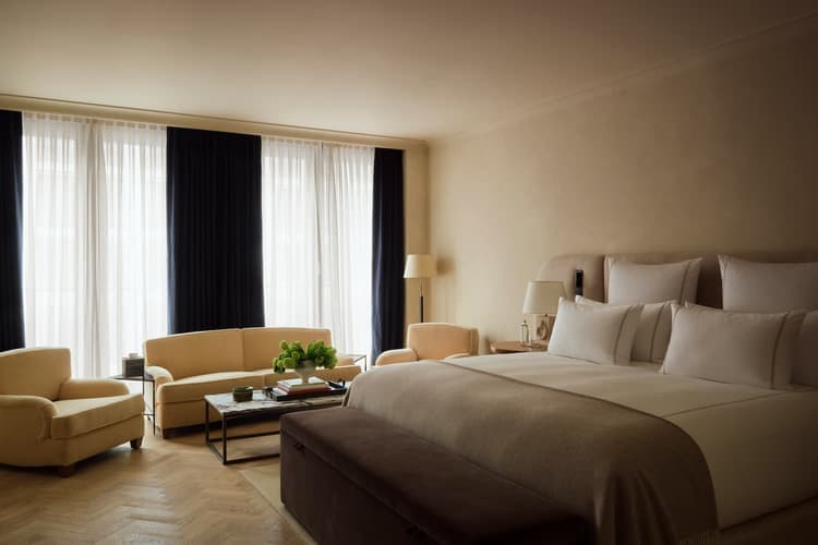 A neutral hotel room with a large bed and seating area